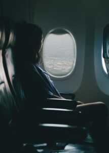 woman sits on seat near window inside plane