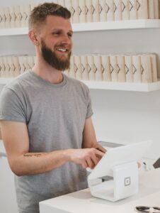 man in grey crew-neck t-shirt smiling to woman on counter